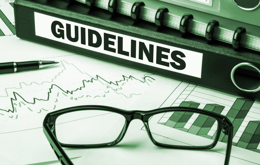 guidelines binder on desk with glasses